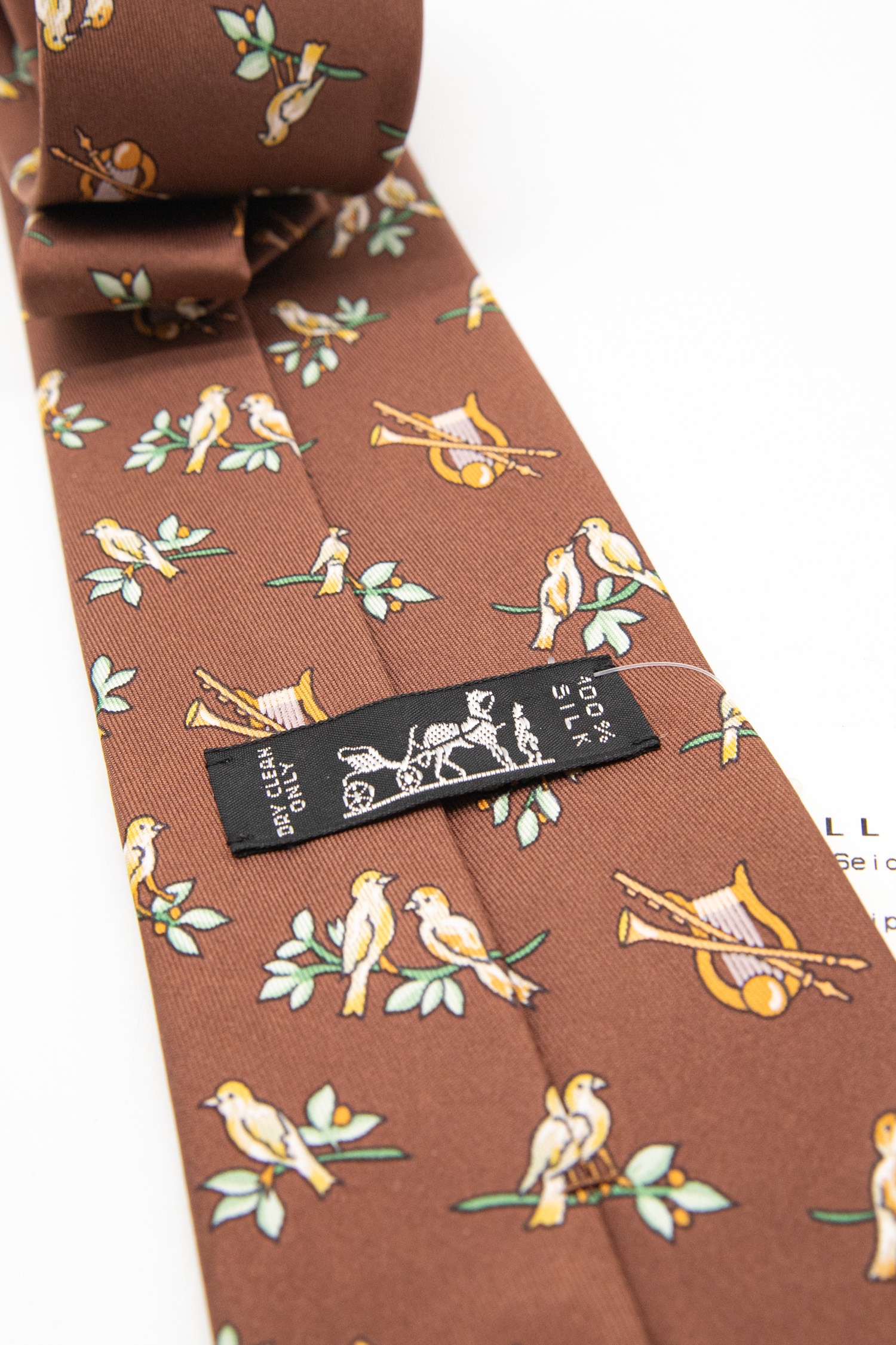 Hermès Krawatte mit Vögeln und Instrumenten in Dunkelbraun